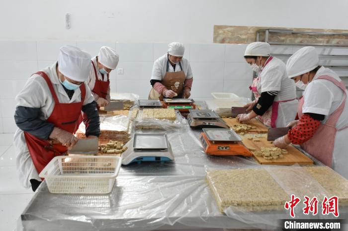 工人正在制作核桃为原料的麻仁糖。　阿卜杜麦吉提·麦麦提伊敏 摄